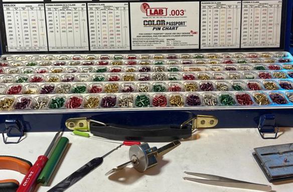 Lock rekeying kit with assorted pins, locksmith tools, and cylinder for professional keying.